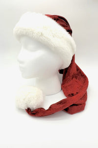 Red Velvet Santa hat with a fluffy white faux fur trim and large white pom-pom, displayed on a white mannequin head against a plain background.
