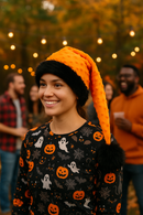 Adult wearing handmade Orange Bumps holiday hat with black faux-fur trim and oversized black pom, long drooping design.