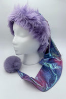 Mannequin head wearing a whimsical hat with a fluffy lavender faux fur trim and a long, shimmering pastel tie-dye fabric tail, finished with a matching lavender pom-pom at the end.