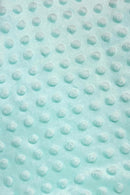 Close-up of light aqua-blue minky fabric with a raised dotted texture pattern.
