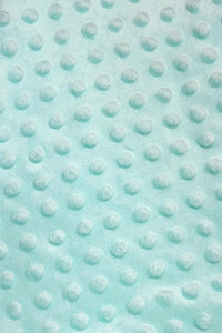 Close-up of light aqua-blue minky fabric with a raised dotted texture pattern.