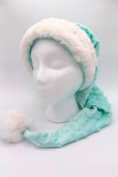 Light aqua blue minky Santa-style hat with raised dot texture, trimmed in white faux fur, and finished with a fluffy white pom-pom, displayed on a white mannequin head.
