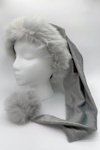 A silver Velvet  with a subtle embossed star patternSanta-style hat with fluffy gray faux fur trim and a large matching pom-pom, displayed on a white mannequin head.