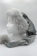 Gray faux fur trimmed Santa-style hat of a silvery gray Velvet with embosssed stars, jeweled accents, and a fluffy matching pom-pom, displayed on a white mannequin head.