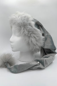 Gray faux fur trimmed Santa-style hat of a silvery gray Velvet with embosssed stars, jeweled accents, and a fluffy matching pom-pom, displayed on a white mannequin head.