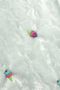 Light blue furry textured fabric with two small decorative patches shaped like colorful ice cream cones, one with purple and pink scoops and the other with turquoise and pink scoops, both with green cones.