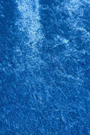 Close-up view of a blue crushed Velvet fabric, showing its soft texture, sheen, and light reflections that create a shimmering effect.