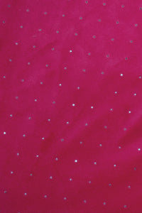 A close-up of a bright pink fabric with small, evenly spaced silver rhinestones scattered across the surface, creating a sparkling effect.