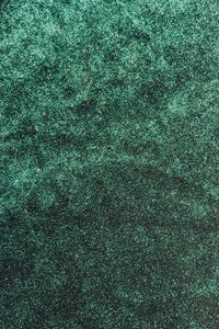 Close-up of dark green Velvet fabric with a wavy, iridescent sheen.