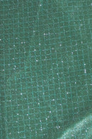 Close-up of a mossy green fabric with a subtle grid pattern and shimmering glitter highlights, reflecting light across the surface.