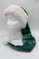 A long green Velvet Santa-style hat with a white faux fur trim and fluffy white pom-pom, displayed on a white mannequin head against a plain background.