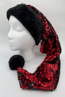 A mannequin head wearing a festive Santa-style hat with a black faux fur brim and a long, pointed body covered in shiny red and black sequins, ending in a black faux fur pom-pom.