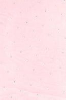 Light pink fabric with a scattered pattern of small, round silver rhinestones evenly spaced across the surface.