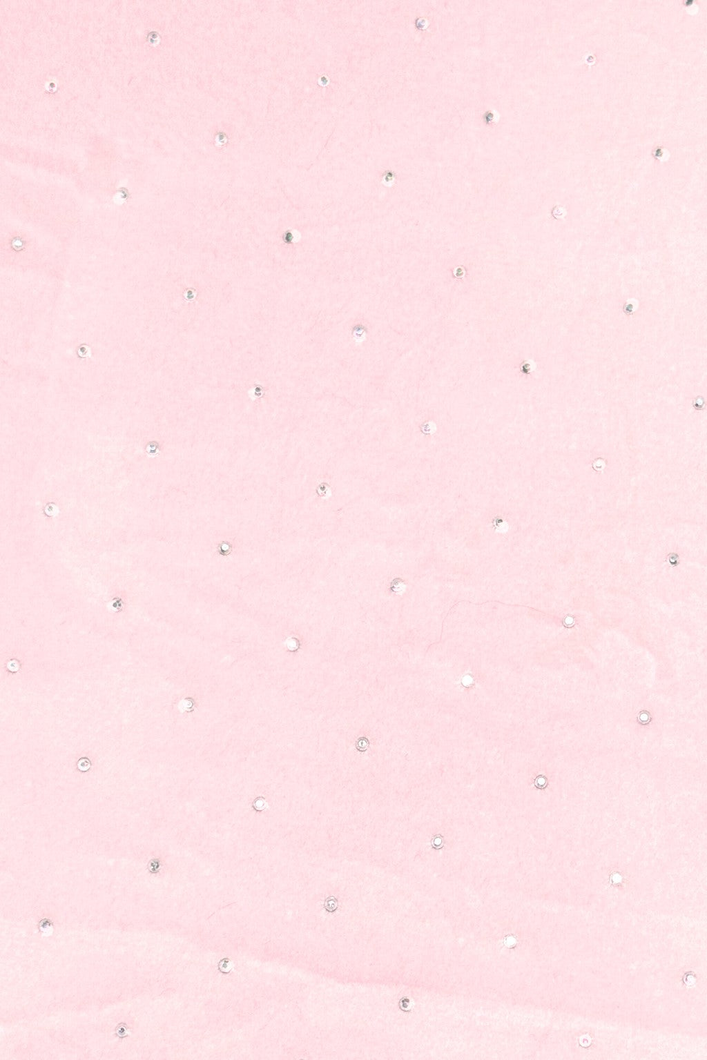 Light pink fabric with a scattered pattern of small, round silver rhinestones evenly spaced across the surface.