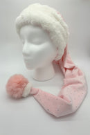 A long pink Velvet Santa-style hat with small silver rhinestones, featuring a fluffy white fur brim and a large soft pink pom-pom, displayed on a white mannequin head. There is a small white fur accent on the top of the pom-pom.