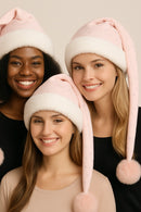Three women wearing pink bunny hats with white fur and pink ears against a neutral background