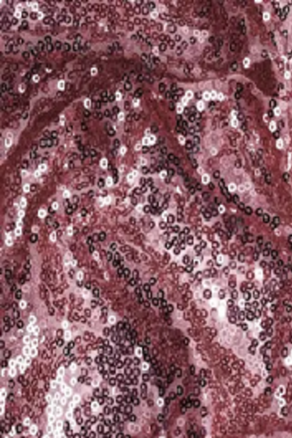 Close-up of shimmering pink and rose-colored sequin fabric with light reflecting off the sequins, creating a sparkling, textured surface.