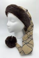 Mannequin head wearing a Burberryg tan plaid hat with dark brown faux fur trim and a matching fur pom-pom at the tip.